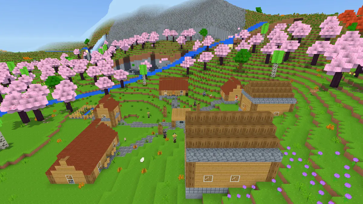 A village of wooden houses among cherry blossom trees, a river and a mountain